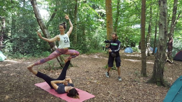 Photo of someone videoing acrobats in the forest